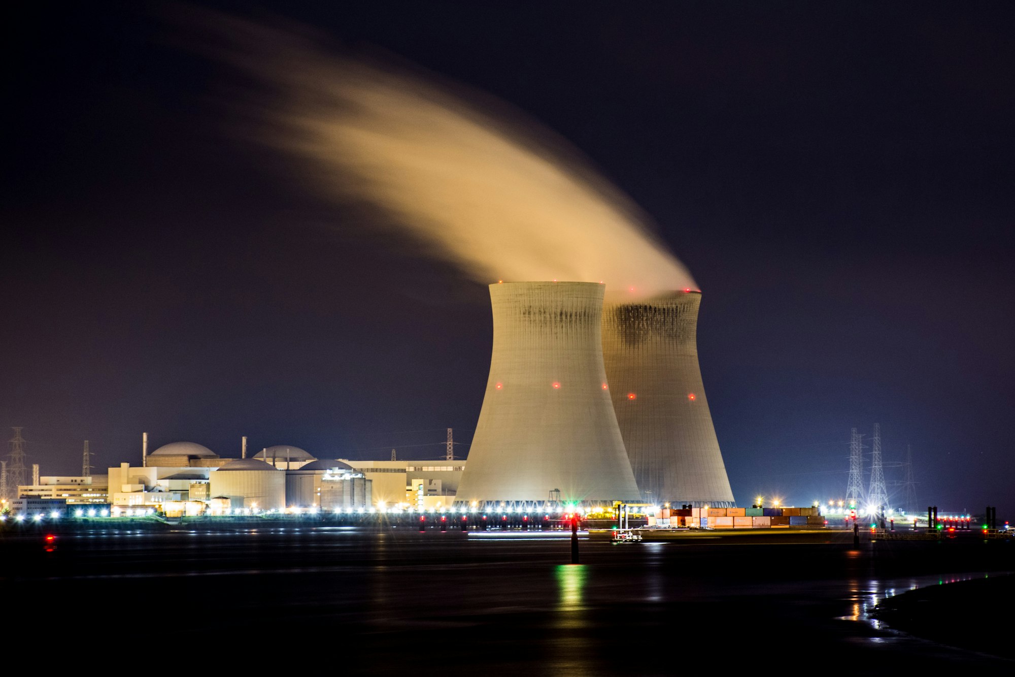 Nuclear cooling towers at night beside a river